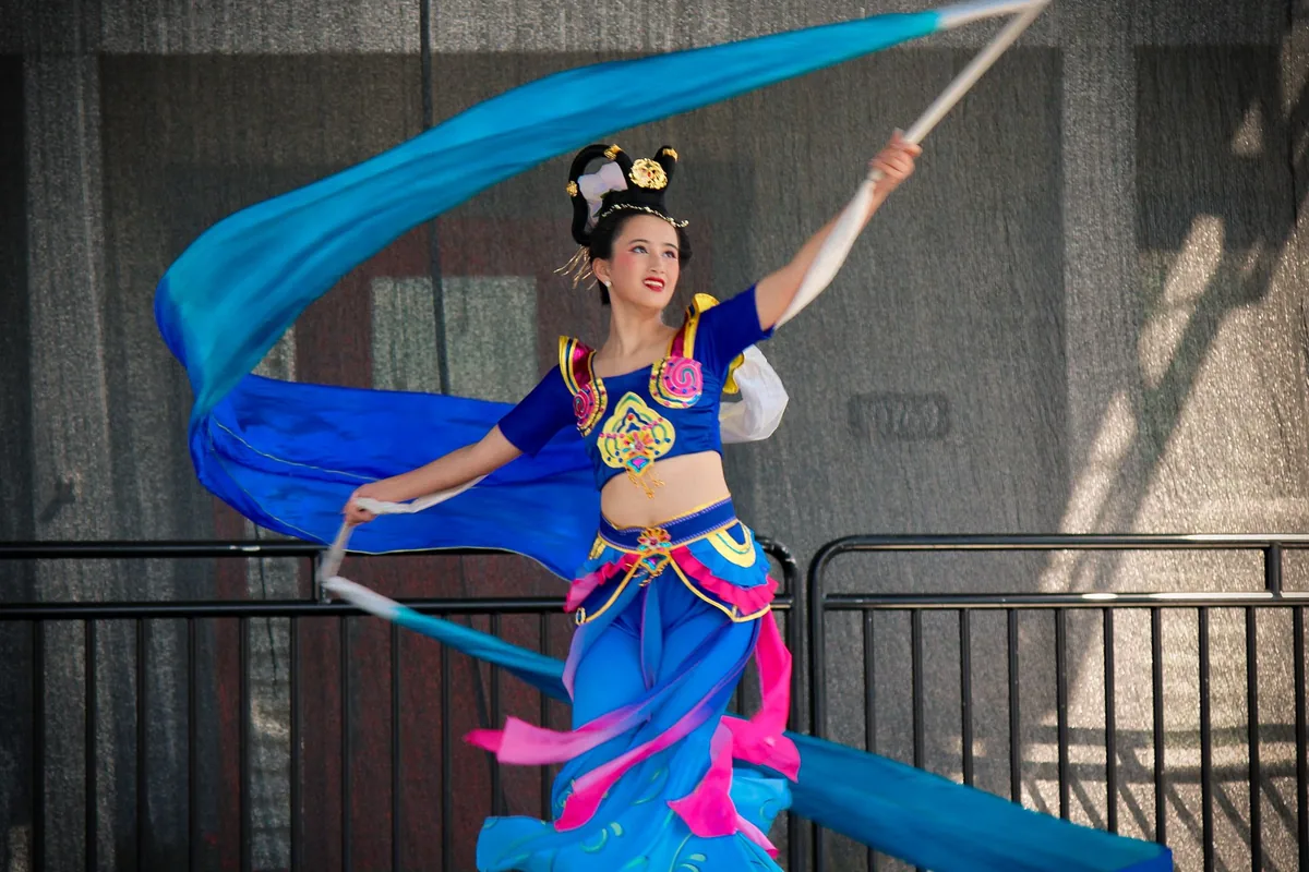 Dancers in traditional Chinese silk costume performing on stage